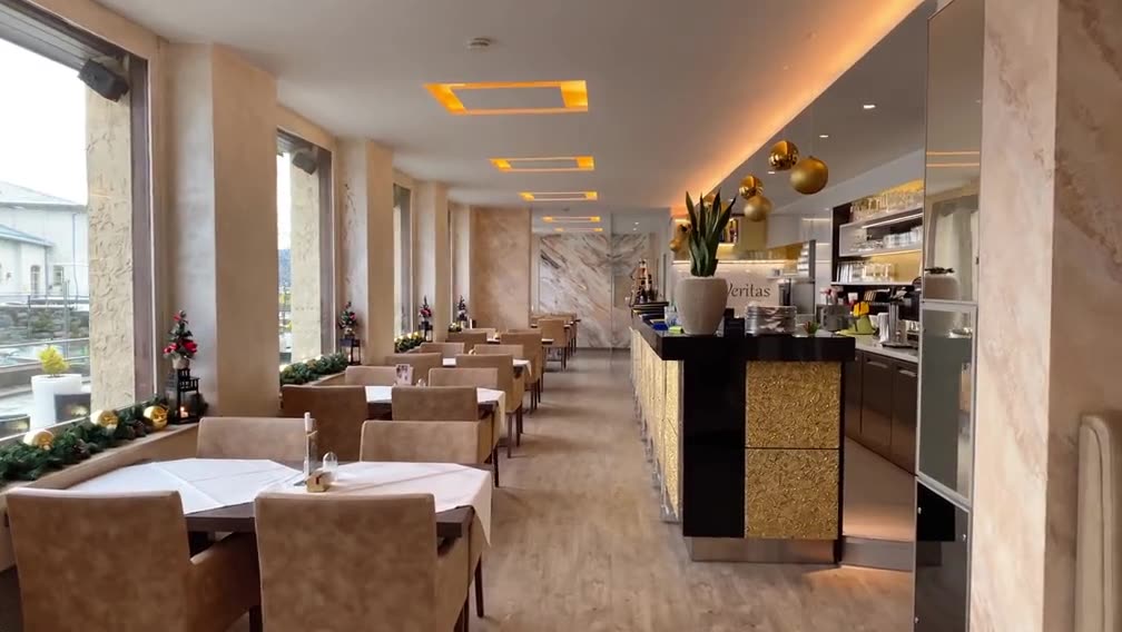 Restaurant mit langer Raumflucht, Tischen am Fenster und Theke im Hintergrund