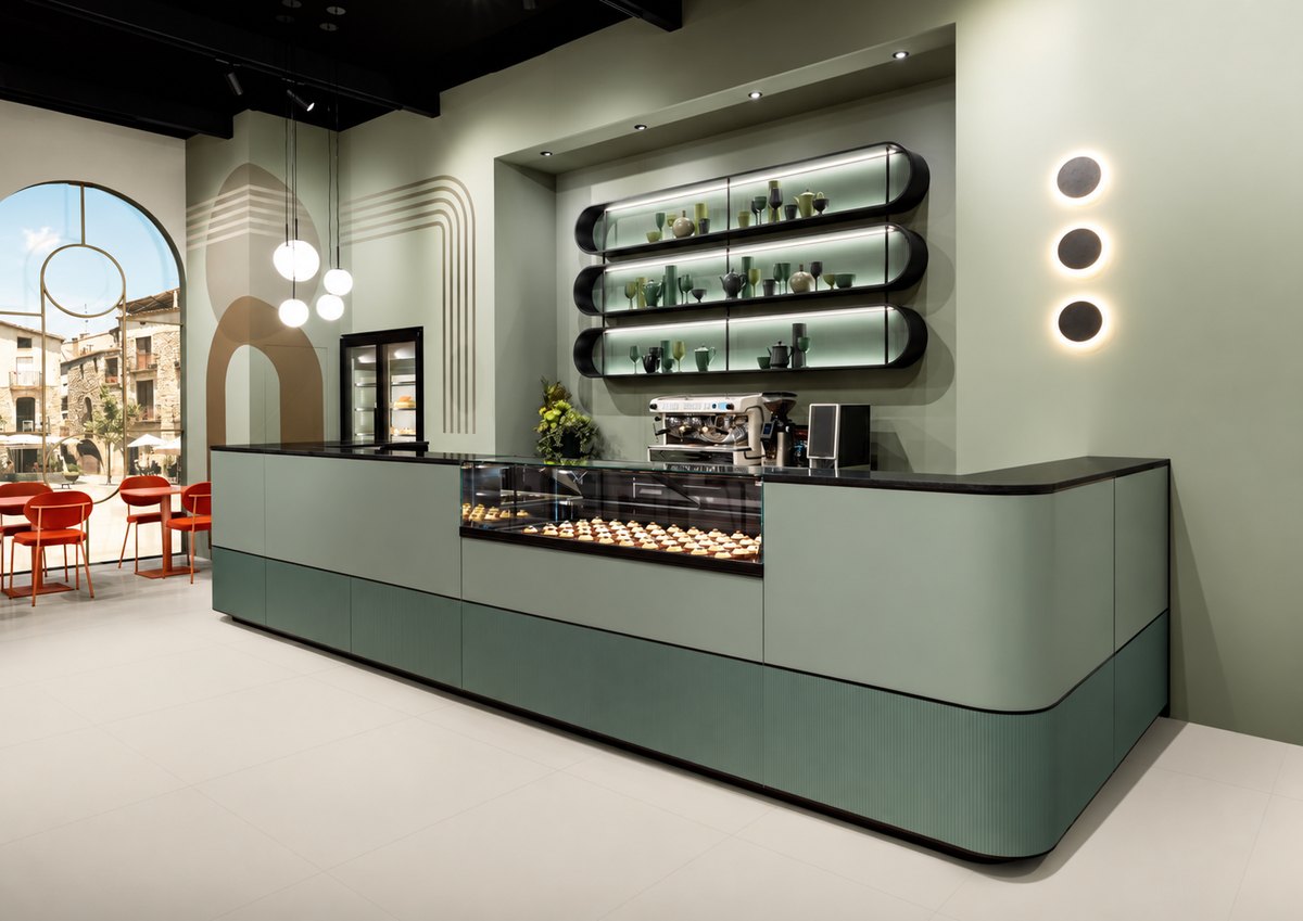 Theke mit Vitrine und gestalteter Wandnische in einem hellen Gastronomieraum