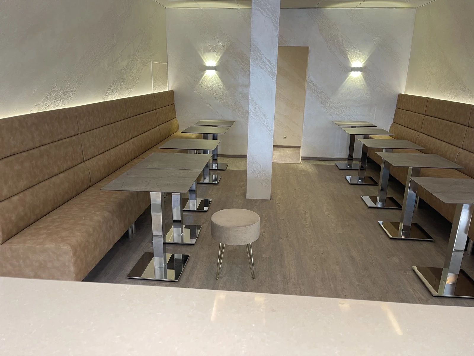 Maßgefertigte Sitzbänke mit gepolsterter Rückwand entlang der Wand eines Cafés