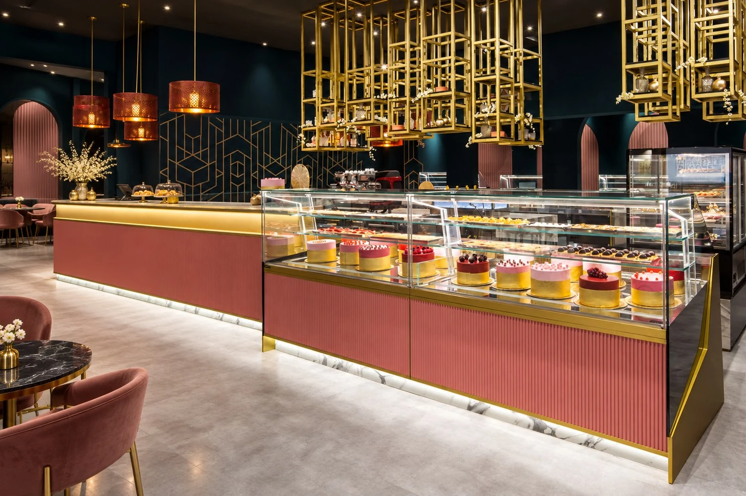 Moderne Gastronomieeinrichtung: Konditorei mit rosa Theke, Gold-Akzenten und Tortenvitrine